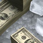 Stacks of money on top of ice cubes.